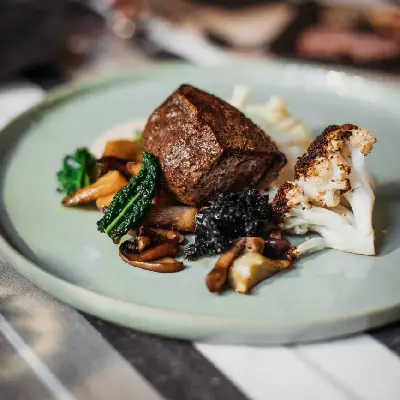 Hirschmedaillon mit Pilz und Gemüse auf Teller angerichtet