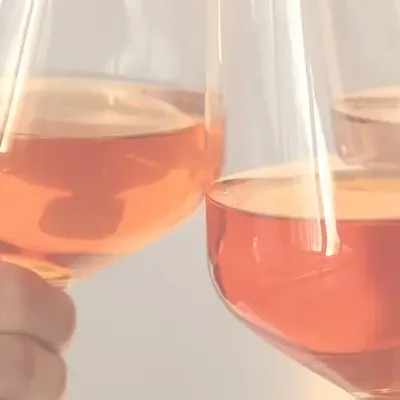 3 Gläser sind mit Orange Wein gefüllt und in der Mitte wird angestossen.