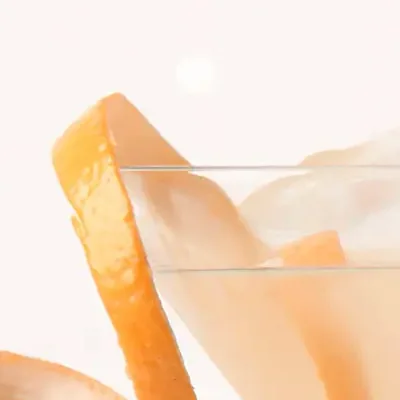 Nahaufnahme eines Drinks mit Orangenschale als Verzierung.